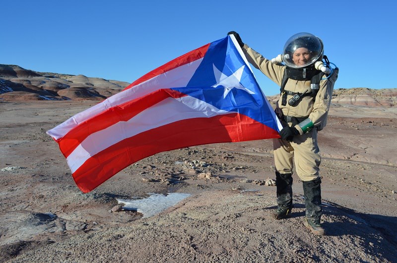 La Dra. Yajaira Sierra-Sastre despliega la bandera de Puerto Rico durante su misión simulada a Marte (Crédito: Sian Proctor)